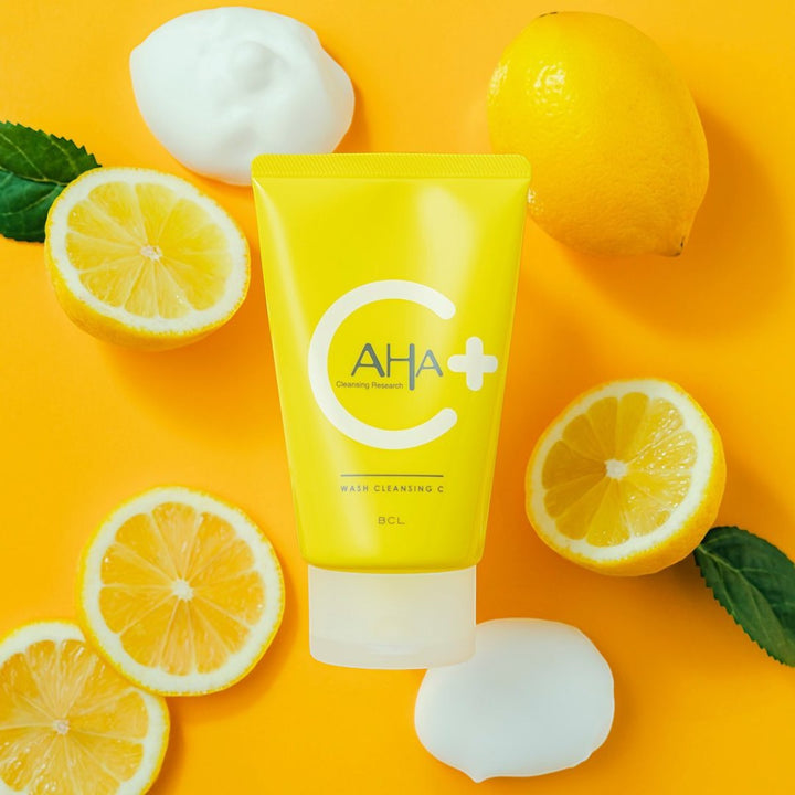 AHA Cleansing Research Wash Cleansing C 120g tub med citroner, gröna blad och skum mot gul bakgrund.