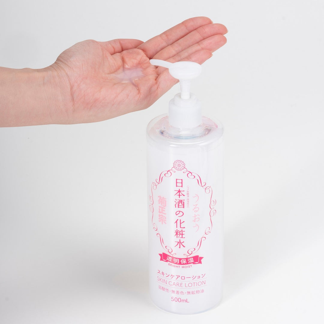 En hand trycker på pumpen till en 500 ml KIKU-MASAMUNE Sake Bright Moist Skin Care Lotion.